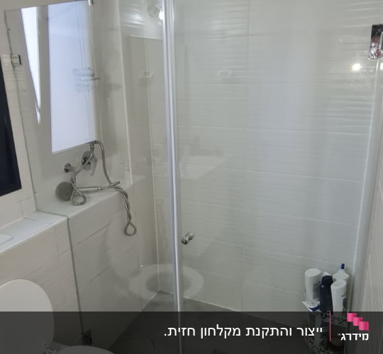 מקלחת עם ראש גשם ודלת זכוכית שקופה